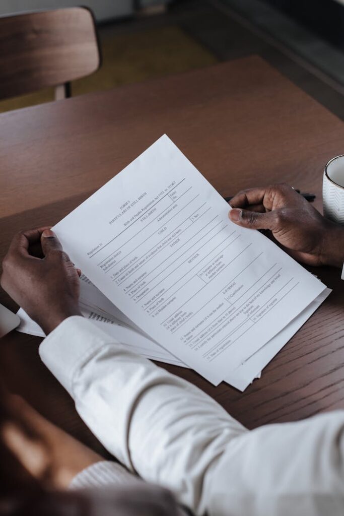 Man in White Shirt Holding Documents in Hands